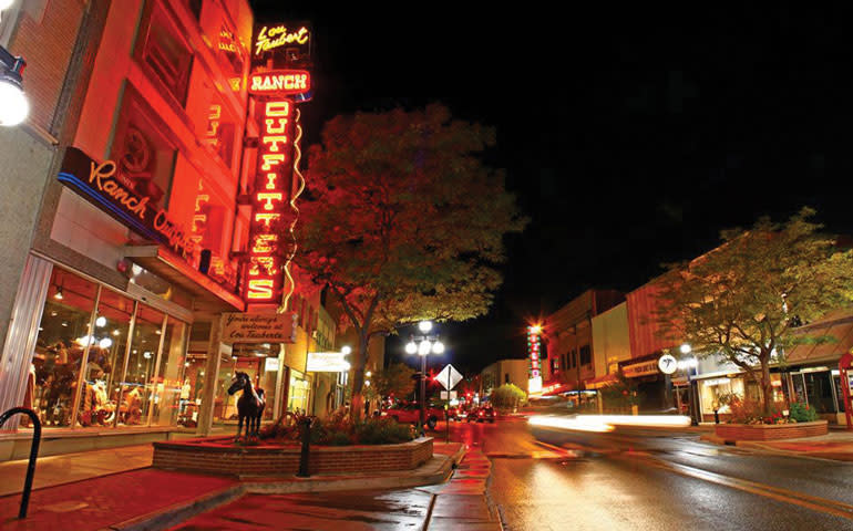 A neon sign glows at night for Ranch Outfitters, a popular place to see in Downtown Casper.