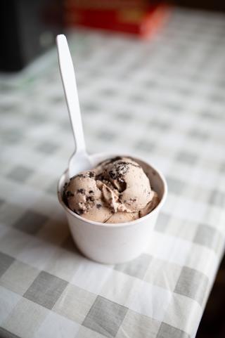 A cup of cookies and cream ice cream with a spoon in it