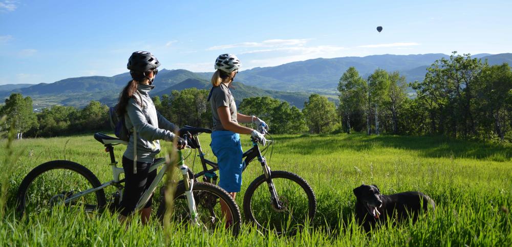 A couple enjoys the views from their bikes on Emerald Mountain