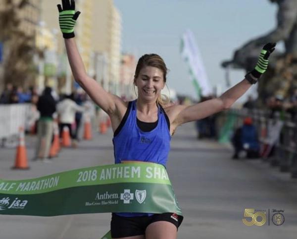 A woman crossing the finish line after running a marathon.