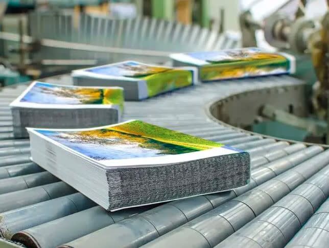 Piles of publications lined up along a conveyor belt