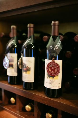 three wine bottles sitting on a shelf