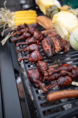 grill filled with meat and corn cobs