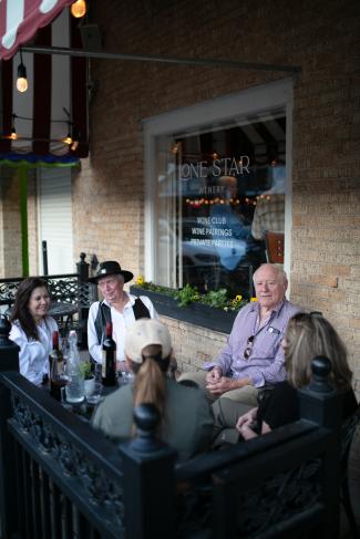people enjoying wine on a sidewalk patio