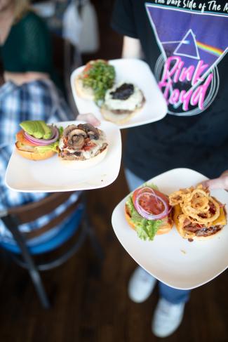 Square Burger - person holding plates of food