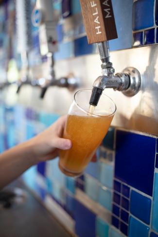 Square Burger - hand pouring draft beer into glass