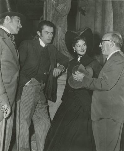 Melvyn Douglas, Gregory Peck, and Ava Gardner speaking with director Robert Siodmak on the set of The Great Sinner.