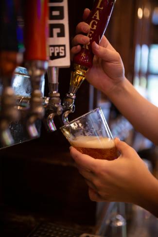 The Pub - hands pouring a draft beer