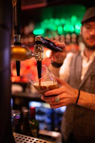 Man pouring a beer at a bar