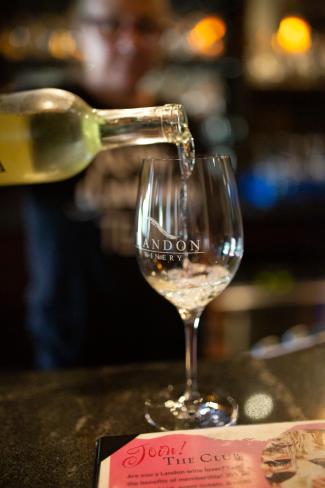 pouring white wine into glass from a bottle