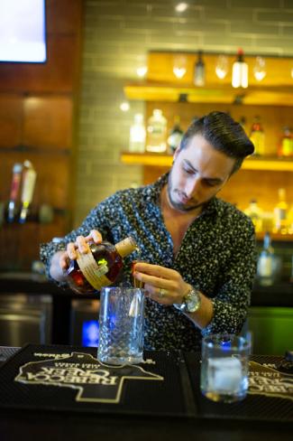 Sugarbacon bartender making cocktail at bar
