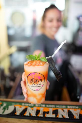 young woman reaching out with a swirled frozen cocktail