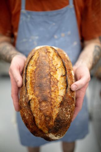 hands holding a loaf of Bresnan bread