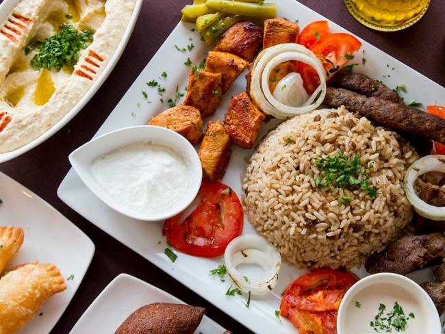 plate with rice, tomato, sauce, and kabob