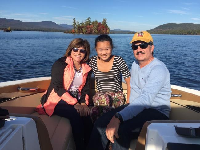 Experience Squam Boating Excursion (Fall) - Happy Family on Boat with Fall Foliage Behind Them