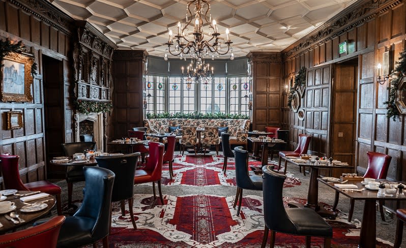A chandalier lights up the restaurant at Ellenborough Park with its wood panelled walls, ornate ceiling and patterned floor