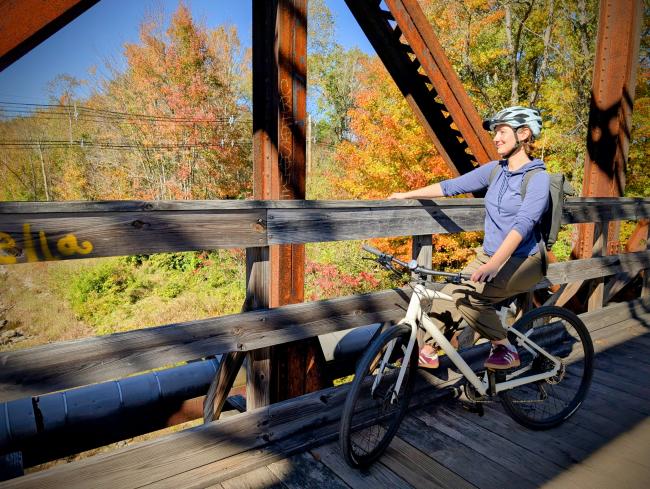 Bicyclist Enjoying View from Trestle Bridge During Fall