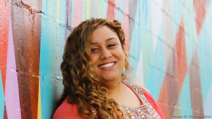 Portrait of Hotel Zazz owner and operator, Dr. Sharmin Dharas, against a colorfully painted mural.