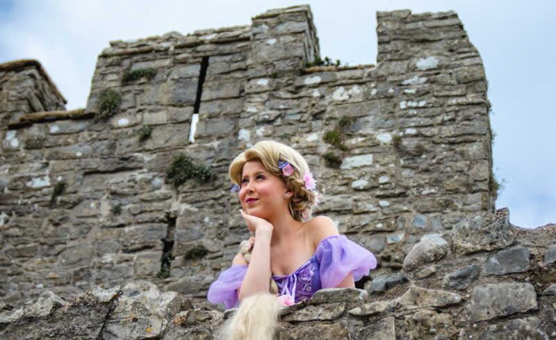 A woman dressed as a princess looking out from Oystermouth Castle