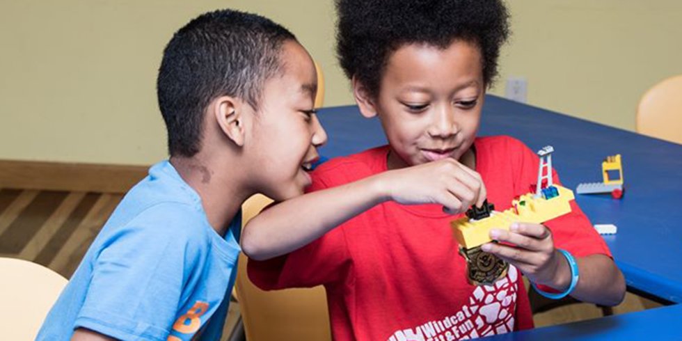 Two Black children play with building toys at the Children's Museum