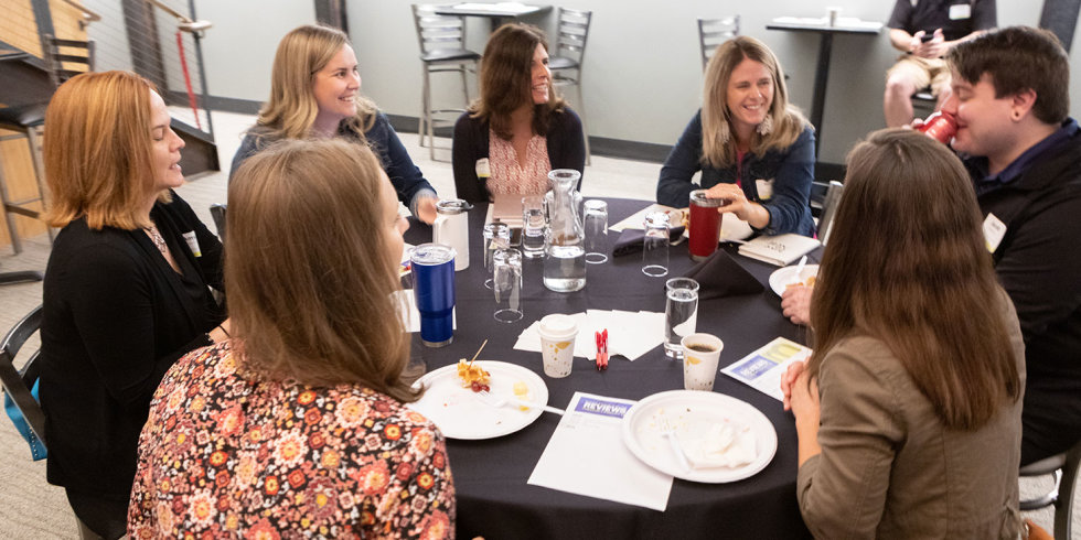 A table of attendees share a laugh while learning to navigate online reviews