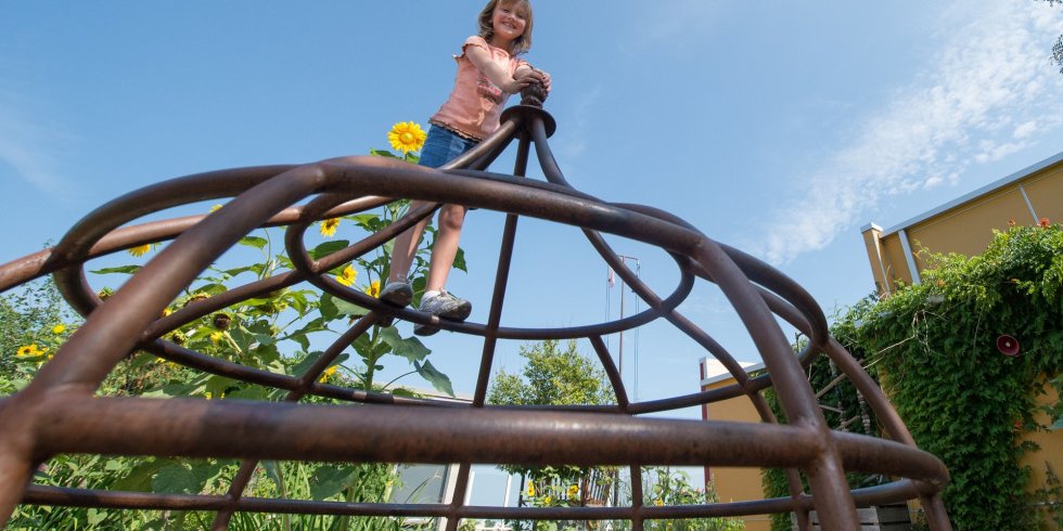 A girl stands on a jungle gym outside of the Madison Children's Museum
