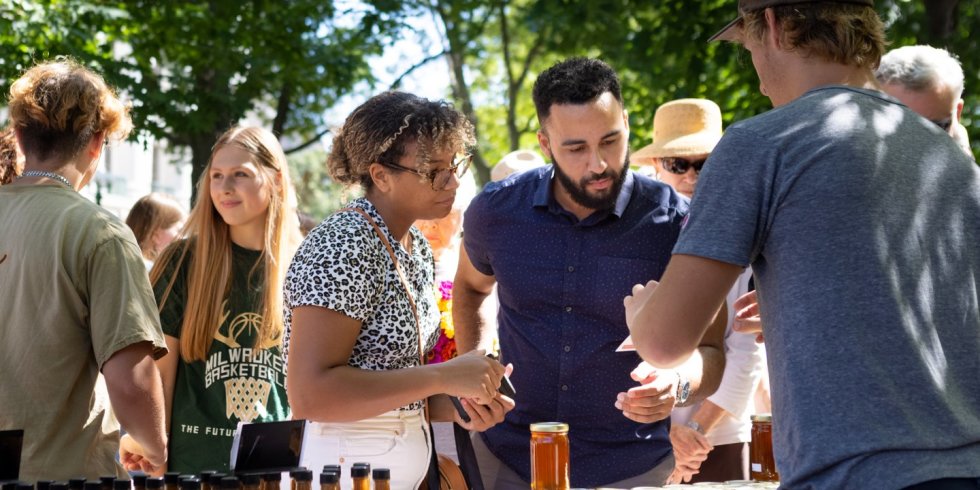 Two people sample salsa at the Dane County Farmers' Market