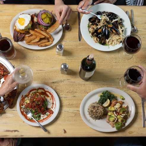 Overhead view of a table with people eating the food in the middle