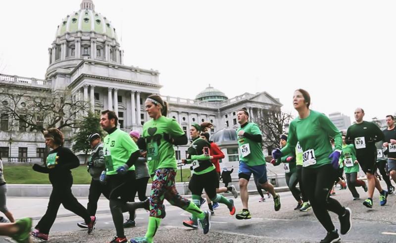 people racing in green in front of the PA Capitol