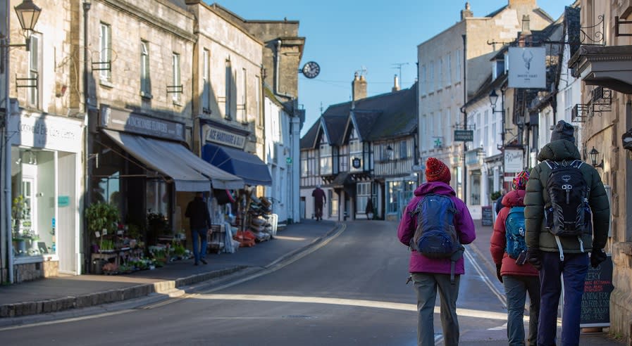 A group of people return from a countryside walk to Winchcombe
