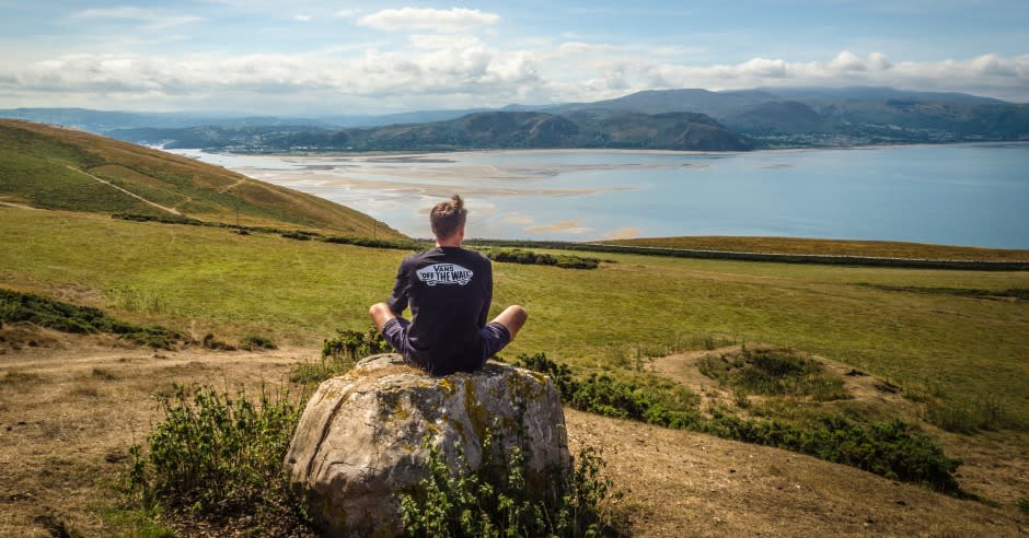 Man sitting on a rock looking out over the landscape