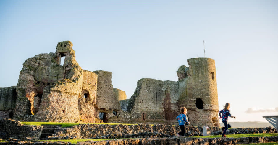 Children playing with Rhuddlan Castle in the background