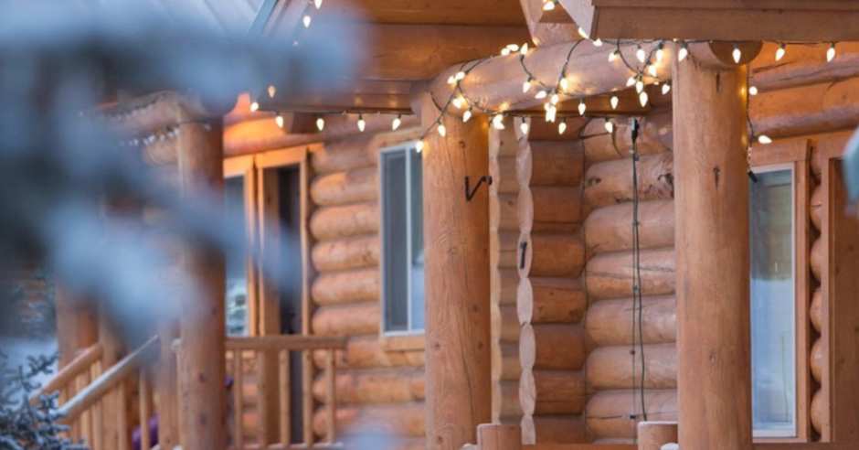 Exterior of a cabin with lights during the winter