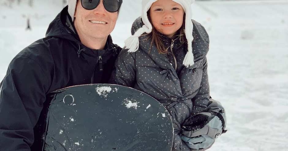 Father and daughter with sled in the snow during winter
