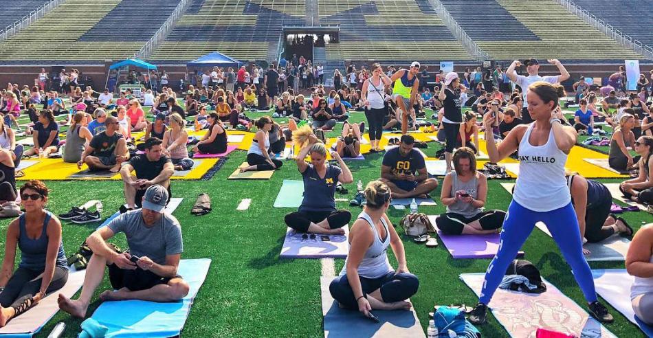People doing yoga in Michigan Stadium