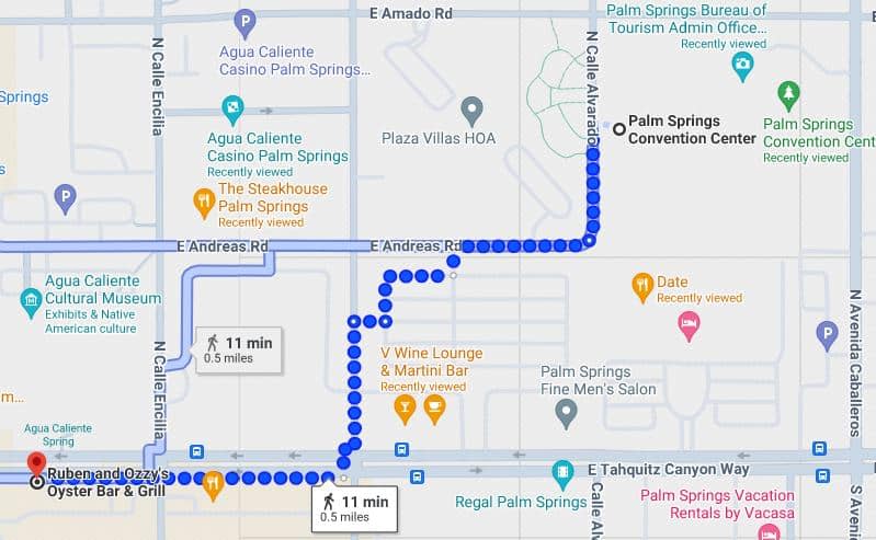 An online map showing two walking routes marked with blue dots between destinations in Palm Springs, both routes estimated to take 11 minutes and cover 0.5 miles. Points of interest are highlighted with icons and labels.
