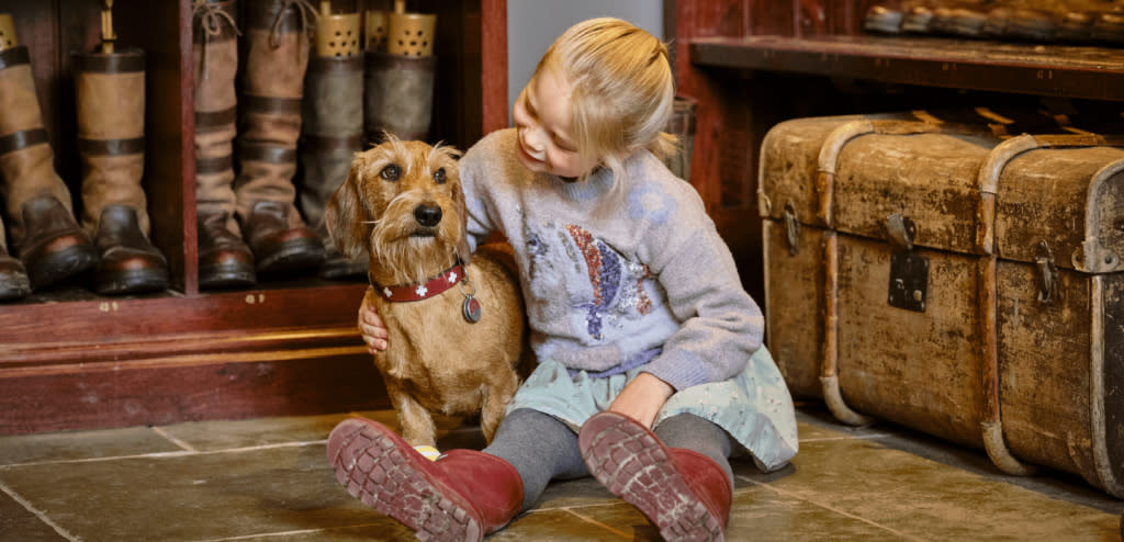 A girl sat with a dog at Ellenborough Park Hotel in Cheltenham