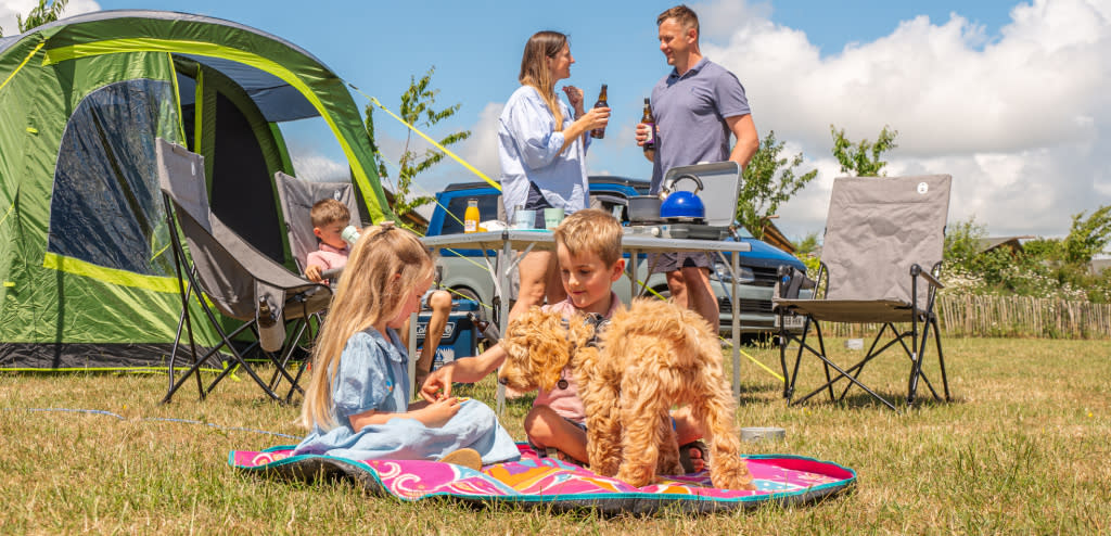 A family with their dog at Cotswold Farm Park Holidays campsite