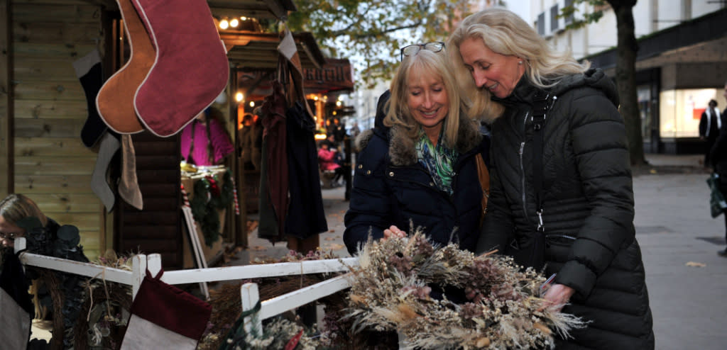 Visitors browsing Cheltenham Christmas markets on the Promenade, Cheltenham