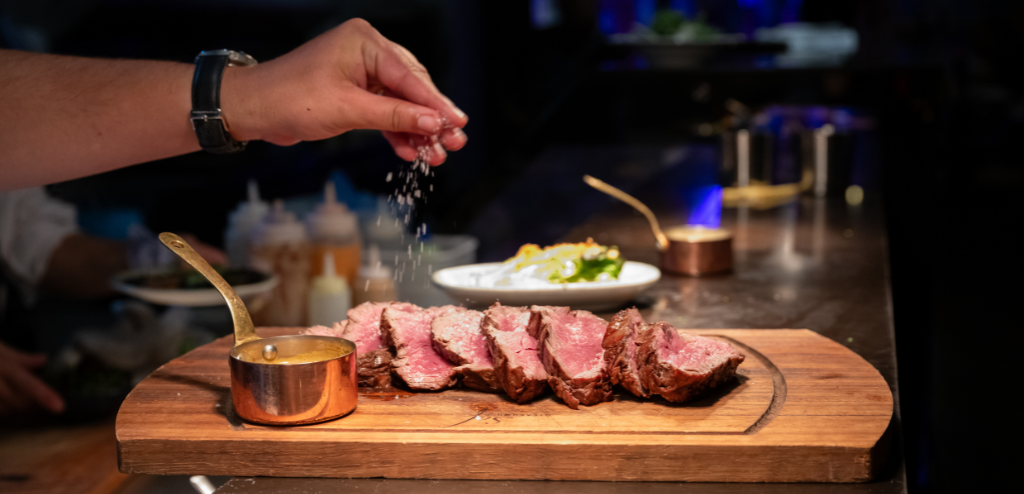 Salt sprinkled on steak at Sef Steakhouse Cheltenham