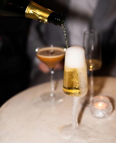 Champagne being poured into a glass, bubble overflowing