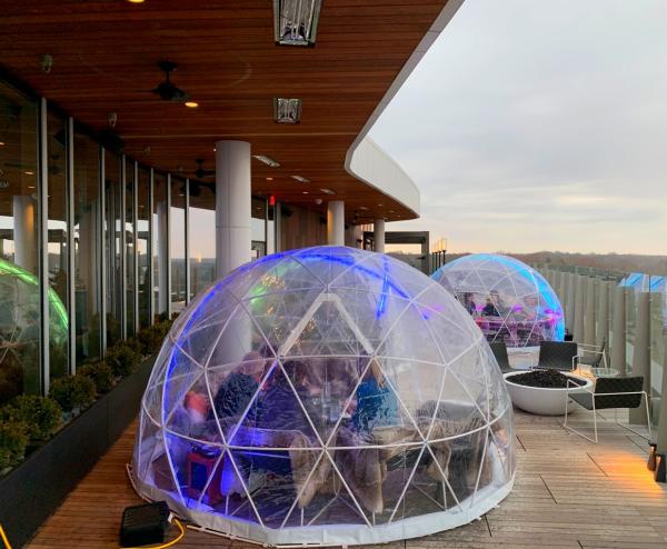 People drinking and dining inside large plastic domes on Vaso Dublin's rooftop lounge