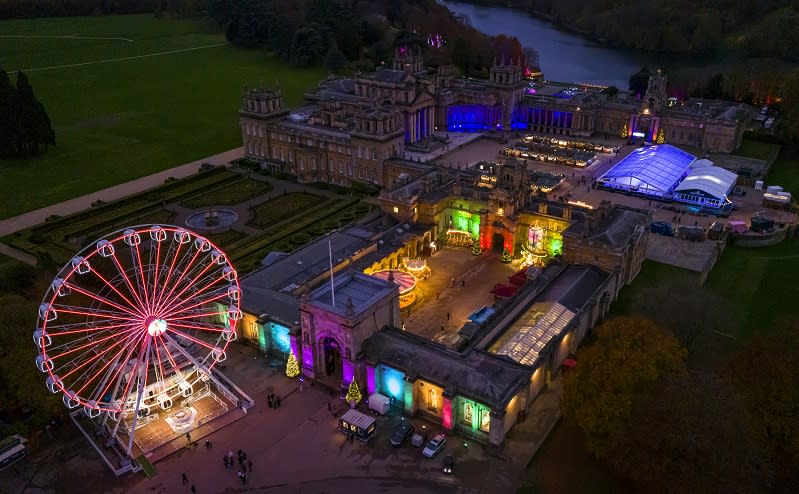 Birds-eye view of Blenheim Palace lit up with Christmas lights, the observation wheel and ice rink