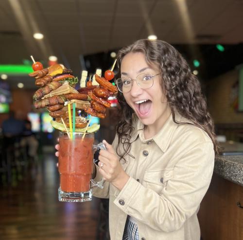 Girl smiling holding oversized bloody mary