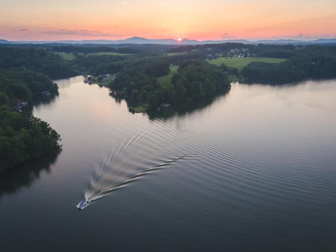 Aerial view of sun setting over Blue Ridge Mountains with Smith Mountain Lake in the foreground