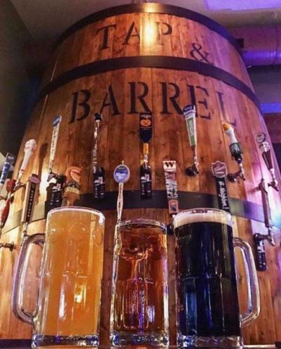 three beers in front of a barrel of beer taps