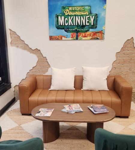 two green chairs and brown couch with Visit McKinney sign