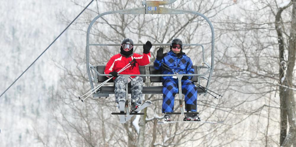 Two skiers at Bristol Mountain waiving on the lift