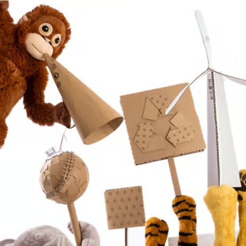 IKEA monkey holding a megaphone as other stuffed toys raise their hands with signs in support of sustainability