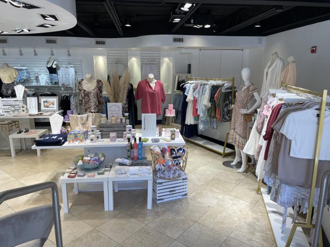 B Boutique interior with racks of women's clothing lining the walls